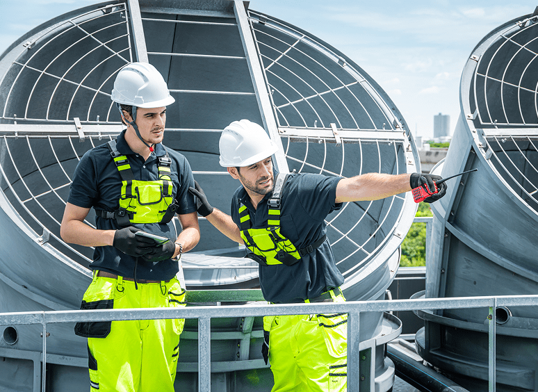 Engineers inspecting industrial rooftop equipment