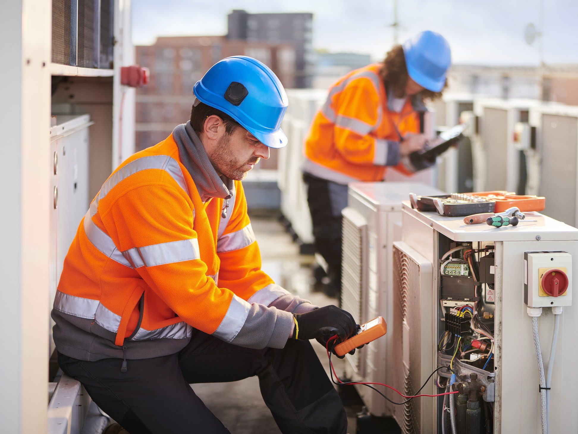Technicians servicing outdoor HVAC units